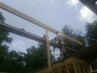 Carpenter setting a ridge beam over a new addition frame — Ice Dam Removal by Roofing Brothers in Lake Elsinore