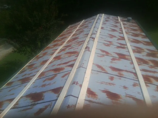 Rusted metal roof panels with new wood purlins before replacement — Storm Damage Roof Repair in Lake Elsinore by Roofing Brothers